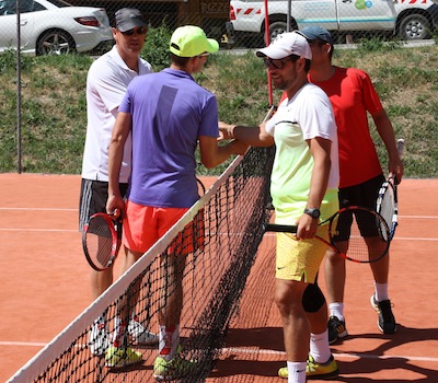 Poigné de main entre les participants de double pendant les animations lors des stages de tennis 